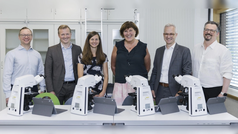 Freude bei der Übergabe der Mikroskope (von links): Dirk Pester (Vorsitzender des Fördervereins des Städtischen Thomas-Mann-Gymnasiums München e.V.), Robin Schmidt (Head of Digital Health Medical Technology), Karolin Dautermann (MINT-Koordinatorin und Fachleitung Biologie des TMG), Karin Moritz (Schulleiterin des TMG), Peter Amend (Head of ZEISS Digital Partners), Leo Pfeifenberger (Head of Software Development Microscopy). (Foto: Das Kraftbild / ZEISS)