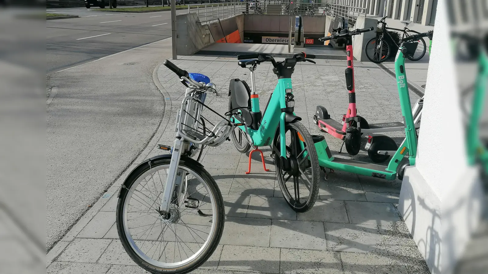 Nichts ist besser geworden: Wie hier am U-Bahn-Zugang Oberwiesenfeld blockieren achtlos zurückgelassene Leih-Scooter und - Räder den kompletten Gehweg. (Foto: job)