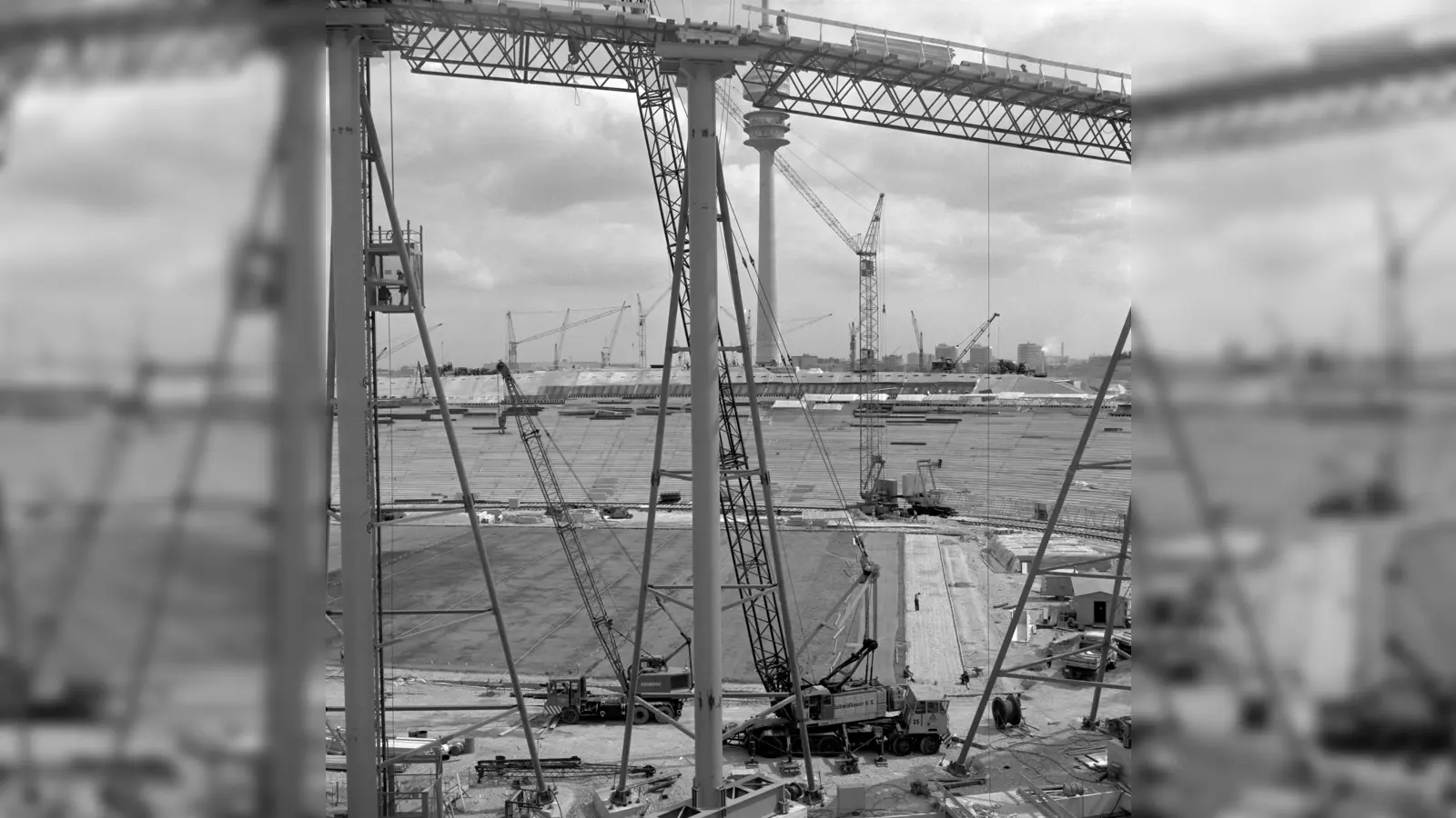 Beim Bau des Olympiastadions: Hier stehen schon die 85 Meter hohen Stahlmasten, die später dann das Seilnetz mit der Dachhaut tragen sollen (Stand: August/ September 1970). (Foto: Stadtarchiv München DE-1992-FS-NL-GRO-315-021)