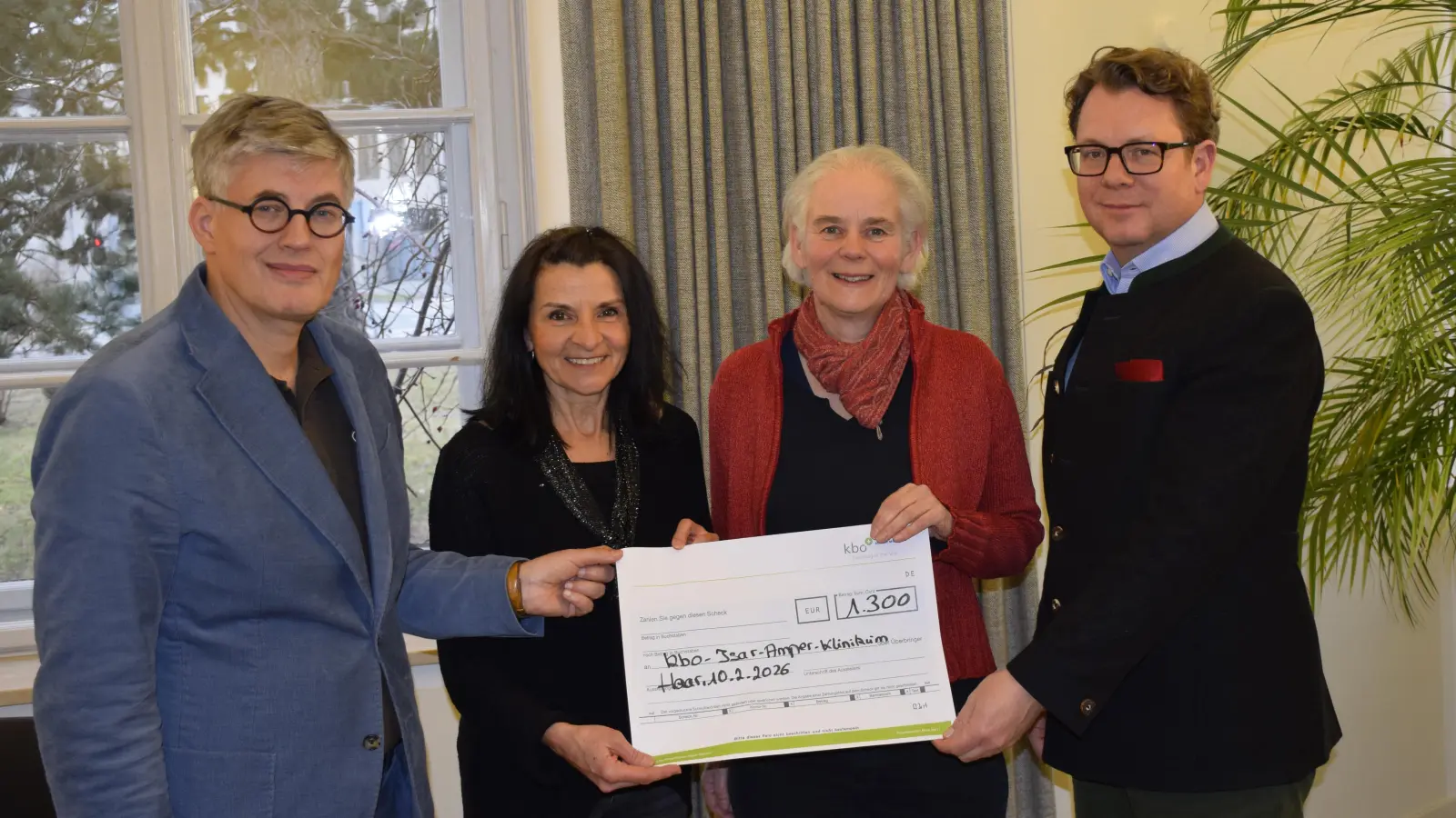 Bei der Übergabe des Spendenschecks (von links nach rechts): Jens Benninghoff, Chefarzt des Zentrums für Altersmedizin und Entwicklungsstörungen, Ellen Schwarz, Leiterin des Chors D'aChor, Ute Rentmeister, Musiktherapeutin, und Nicolas von Oppen, Geschäftsführer des kbo-Isar-Amper-Klinikums. (Foto: kbo-Isar-Amper-Klinikum)