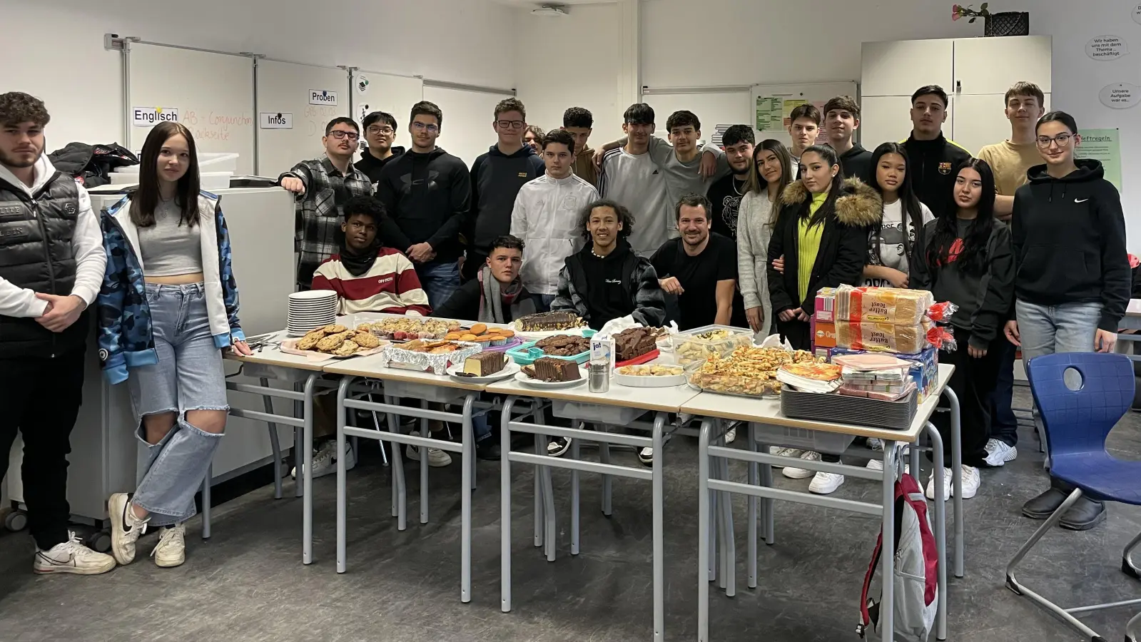 Die Klasse 10V1 vor den appetitlich präsentierten Speisen für den Pausenverkauf. (Foto: M. Heilmeier)