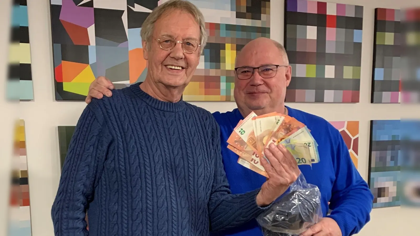 Schiedsrichter Manfred Trautmann (links) übergibt eine Spende in Höhe von 220 Euro an Jörg Göppert vom Verein „Klettham kommt zusammen“.  (Foto: Stadt Erding)