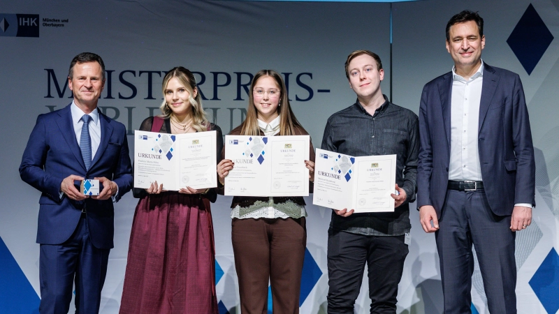 IHK-Hauptgeschäftsführer Manfred Gößl mit den Absolventinnen Paulina Maria Pöhn, Sophia Trautbeck und Michael Bamberg sowie Staatsminister Georg Eisenreich im GOP Varieté-Theater (v.l.). (Foto: Matthias Balk/IHK für München und Oberbayern)