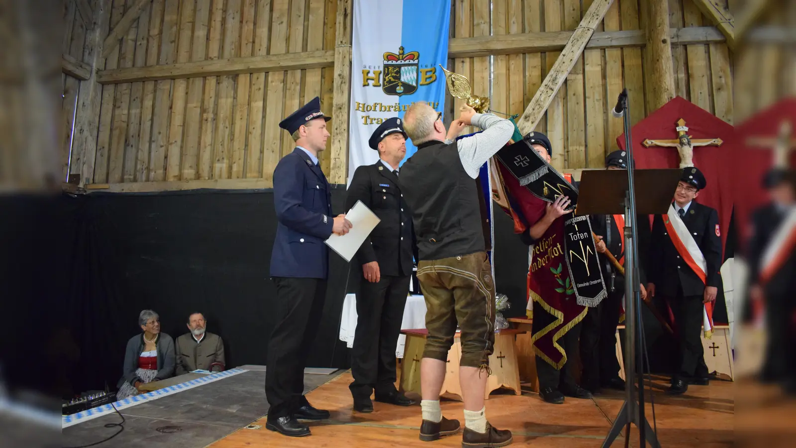 Bürgermeister Holger Jerg beim Befestigen des Fahnenbanners mit Vorstand Peter Voit und Kommandant Markus Mende. (Foto: W. Mende)