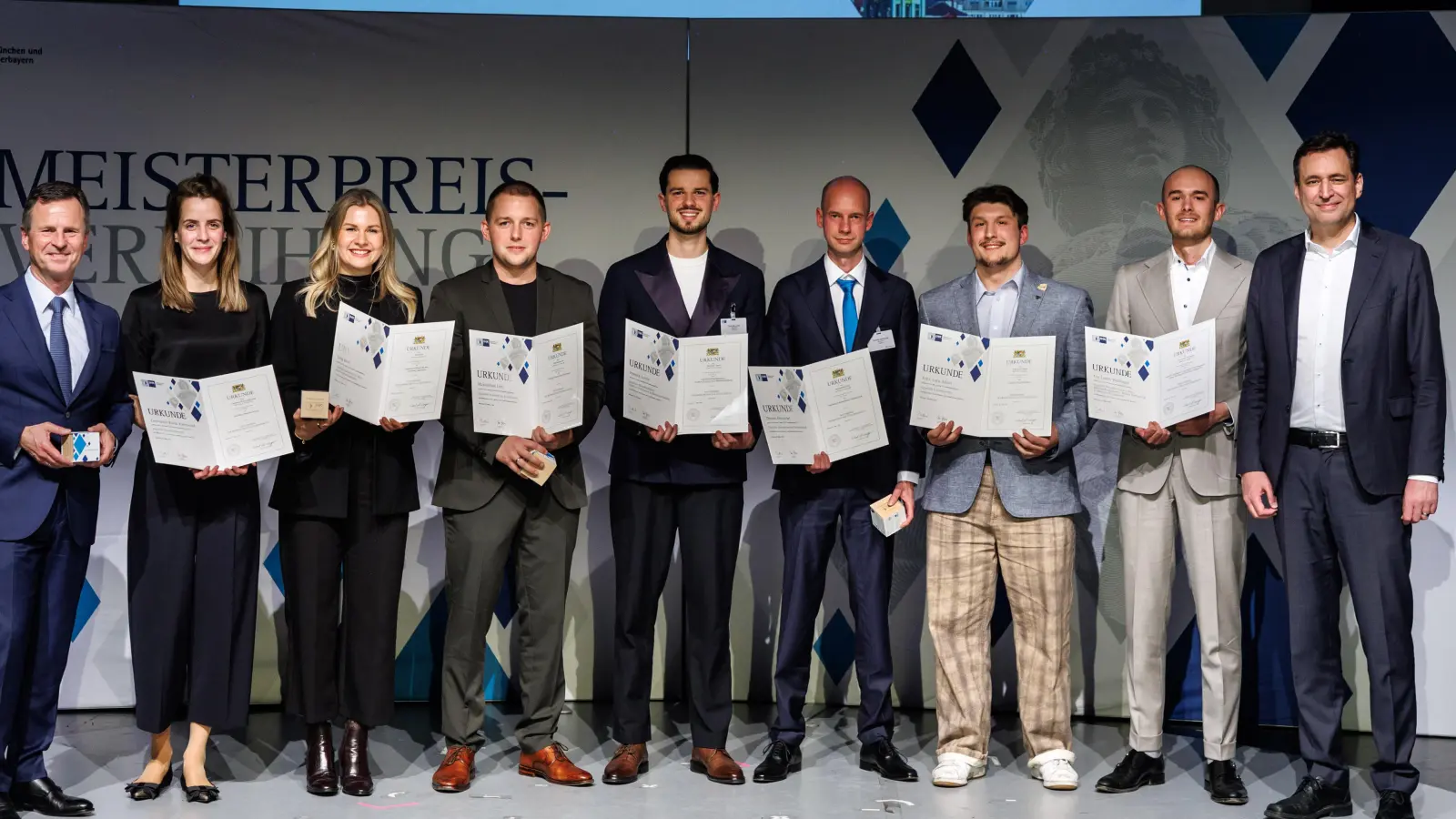 Bei der Preisverleihung (v.l.) Manfred Gößl (IHK), Constanze Rieck-Kahnwald, Lena Kern, Maximilian Löb, Dominik Lovric, Thomas Hentschel, Felix Luca Almer, Tim Cedric Wölfinger und Staatsminister Georg Eisenreich. (Foto: Foto: Matthias Balk/IHK für München und Oberbayern)