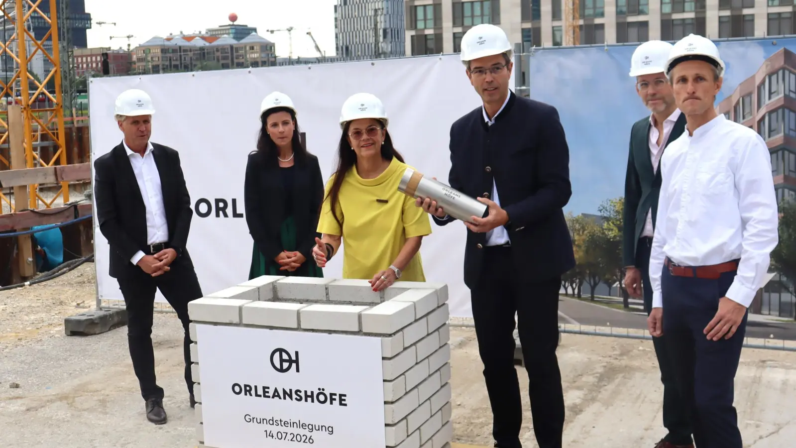 Stadtbaurätin Elisabeth Merk (Mitte) und GVG-Geschäftsführer Thomas Schmid (mit Kapsel) befüllten nach altem Brauch die Zeitkapsel für den Grundstein der Orleanshöfe. (Foto: bas)