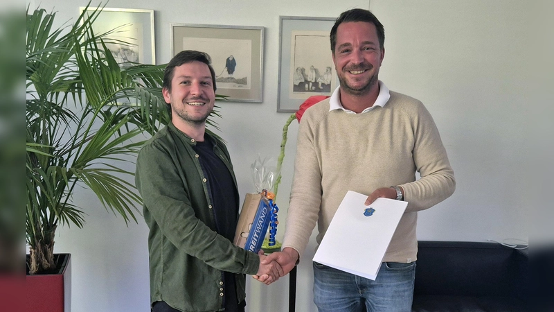 Herzlichen Glückwunsch! Erster Bürgermeister Maximilian Platzer gratuliert Frederic Seifert (l.) zu seinem Abschluss und überreicht den neuen Arbeitsvertrag sowie Kinokarten als Dankeschön für seine in der Ausbildung geleistete Arbeit. (Foto: Gemeinde Gauting)